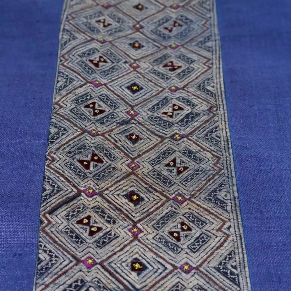 Straight-on shot of blue cushion with vintage H’mong panel
