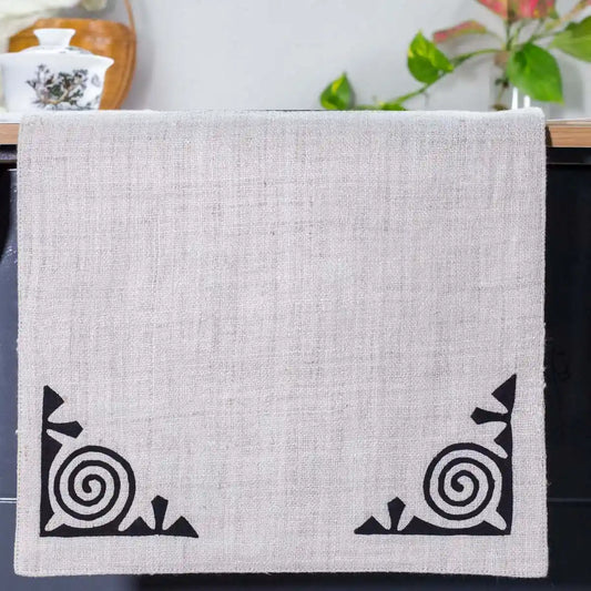 Vindigo beige hemp table runner end view with black spiral embroidery details