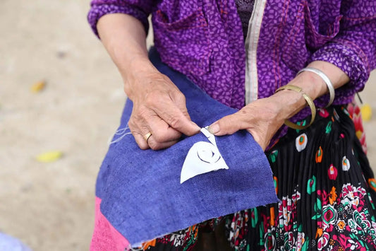 H’mong-hantverkare syr mörkgrått hampakuddfodral för hand