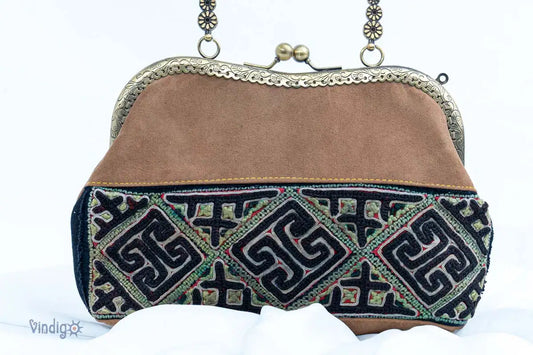 Close-up of brown suede handbag with geometric vintage embroidery