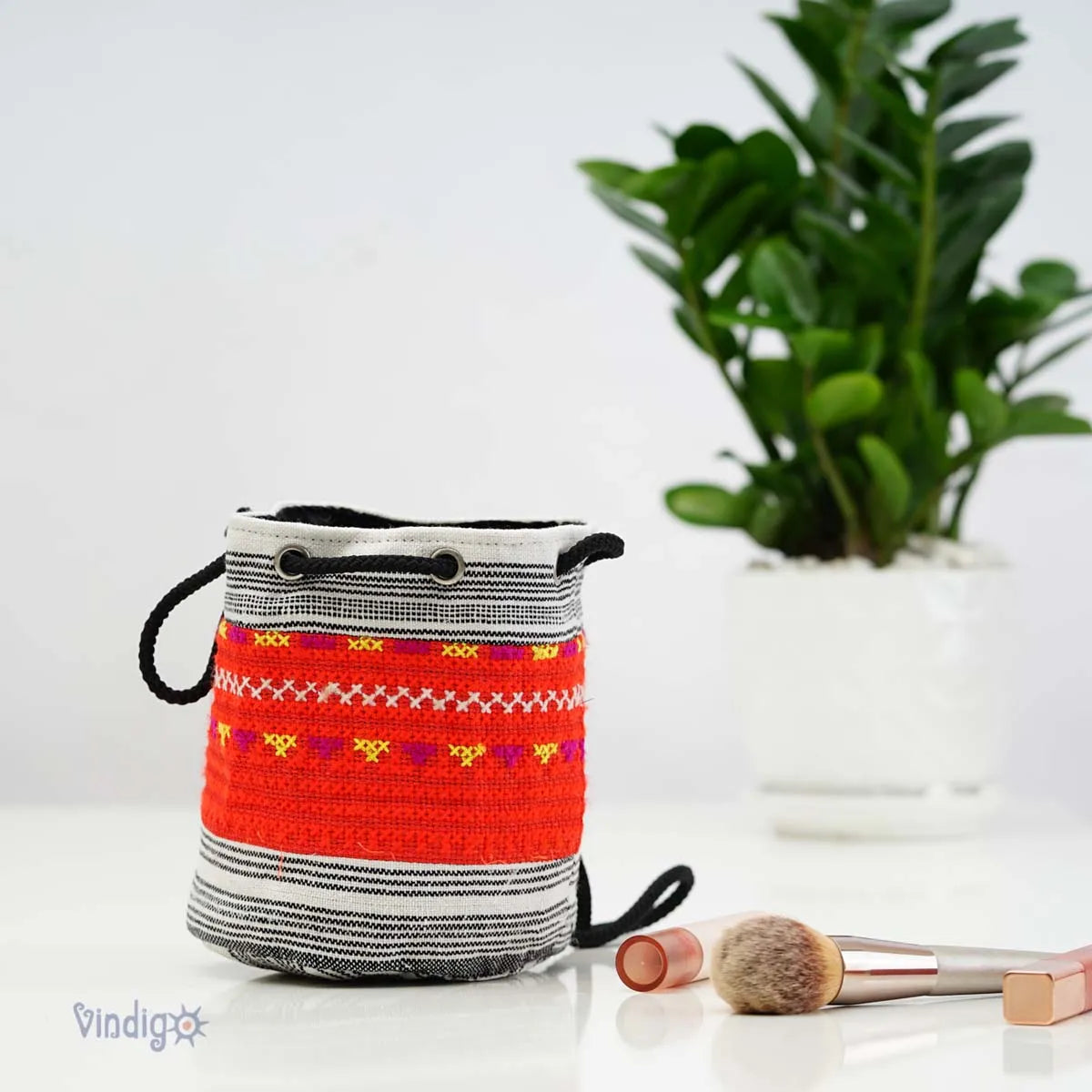 Vindigo red tribal hemp mini pouch styled beside plant lifestyle shot