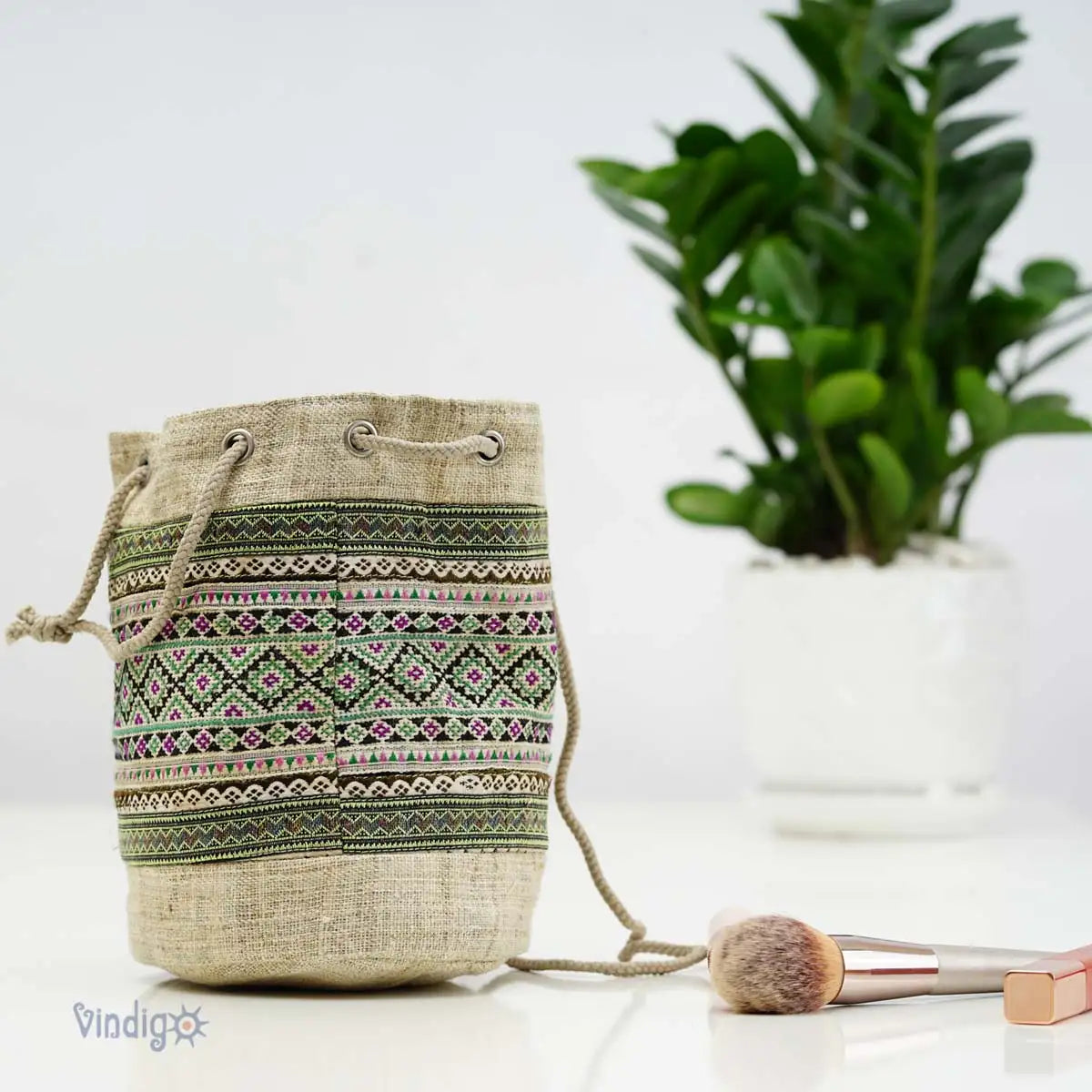 Vindigo green hemp tribal drawstring pouch beside plant lifestyle shot