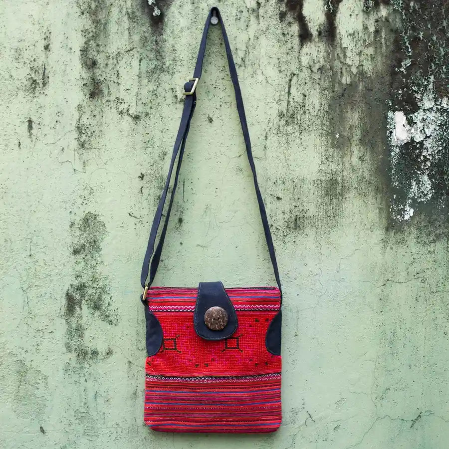 Vindigo red hemp crossbody bag hanging front view against textured wall
