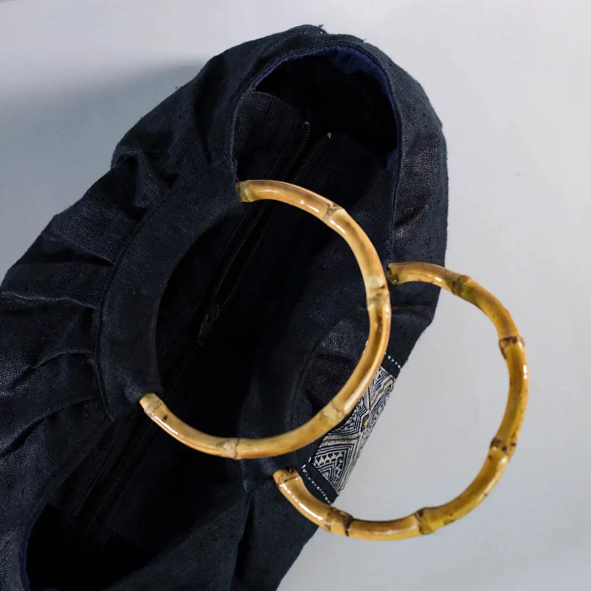 Top view of black hemp handbag with bamboo handle, spacious interior, eco-friendly handmade bag.