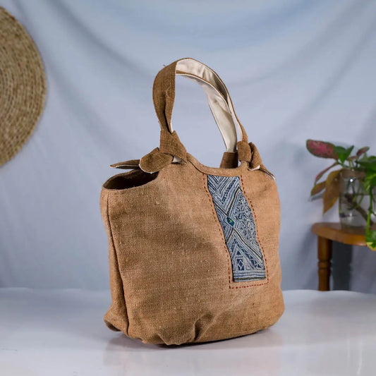 Angled view of brown hemp bunny ear handbag with vintage patch, sustainable handmade bag.