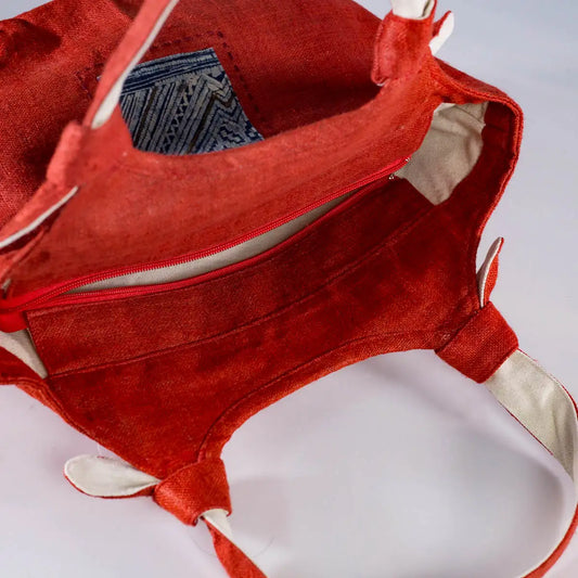 Side view of red hemp bunny ear handbag featuring vintage H’Mong patch, sustainable handmade design