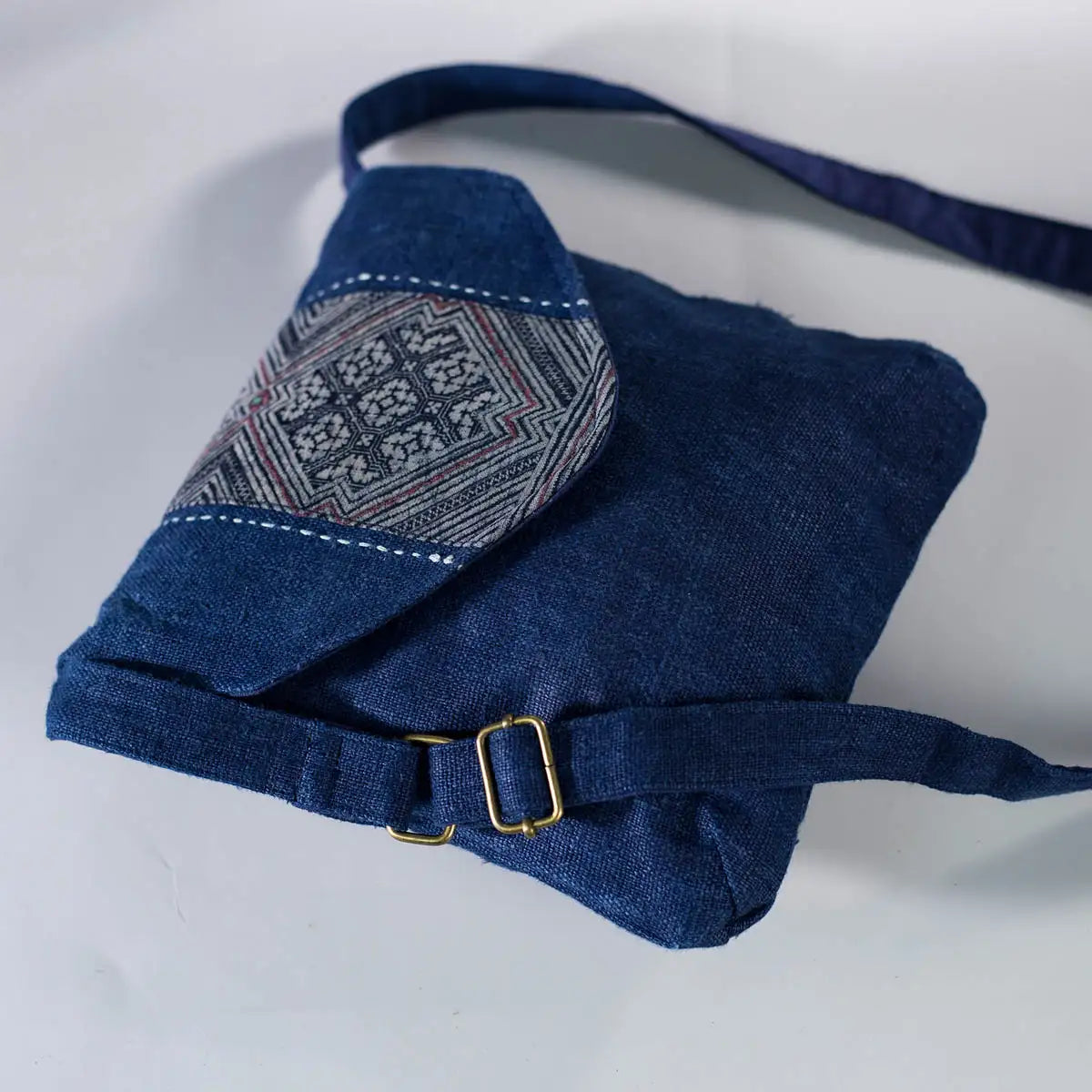 Side view of indigo hemp crossbody bag with strap and H’mong patch