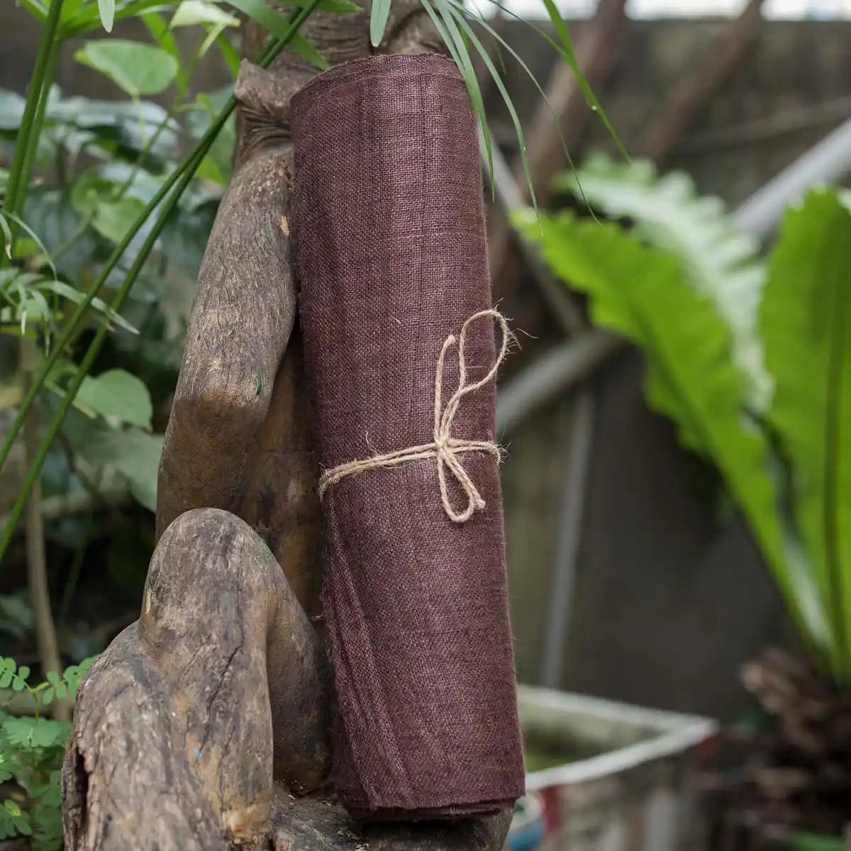 Vindigo brown hemp fabric roll styled outdoors on wooden background