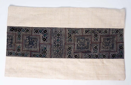 Close-up of indigo embroidered hemp pattern on beige cushion cover