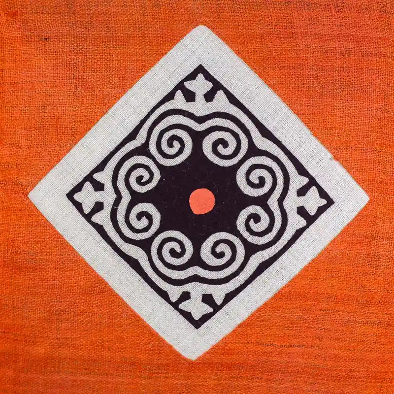 Vindigo orange hemp cushion cover close-up of Hmong spiral embroidery patch