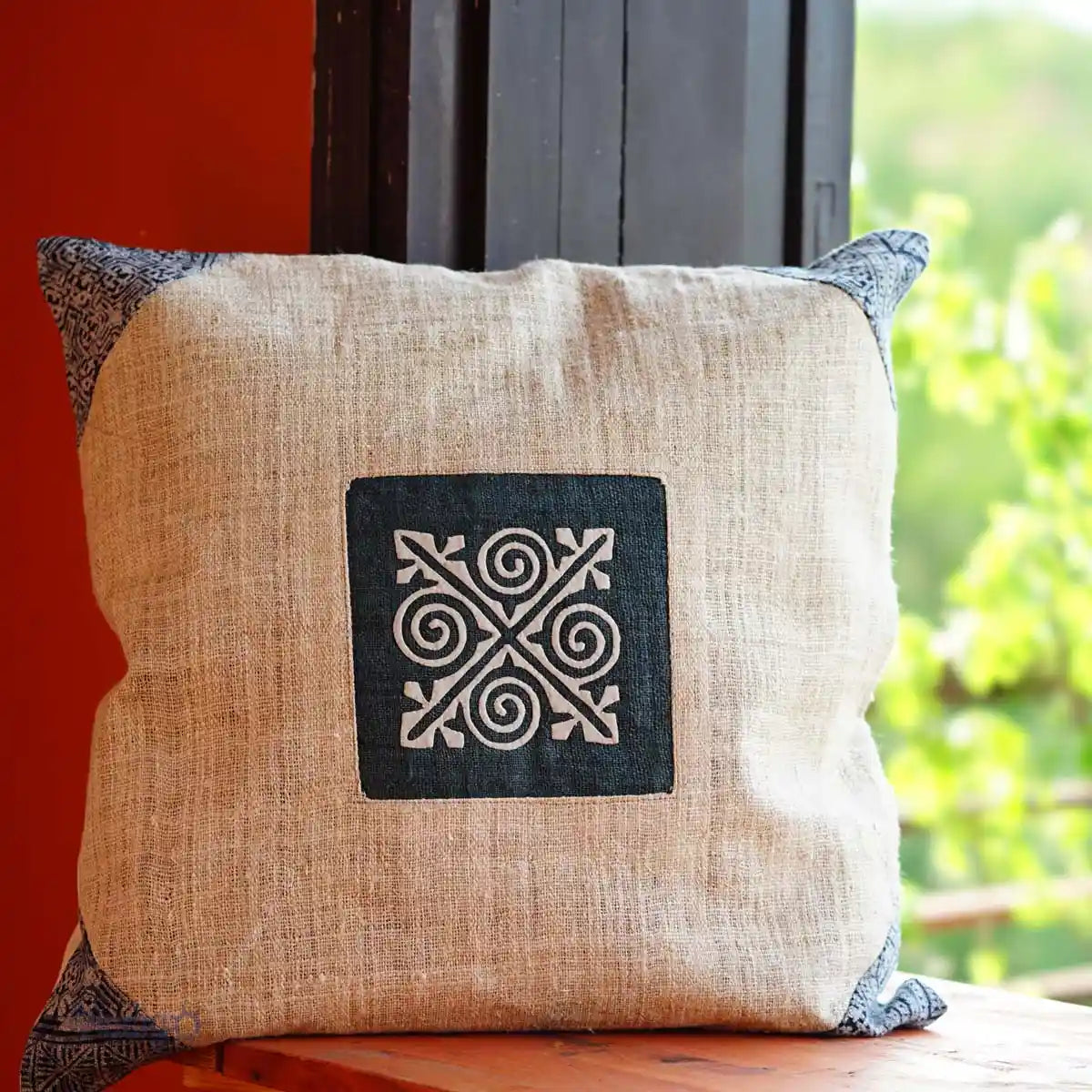Square hemp cushion with indigo batik patch by the window
