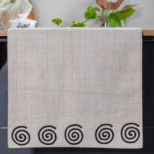 Vindigo beige hemp table runner end view with alternating spiral embroidery design