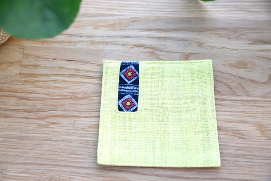 Front view of yellow hemp coaster with indigo embroidered stripe