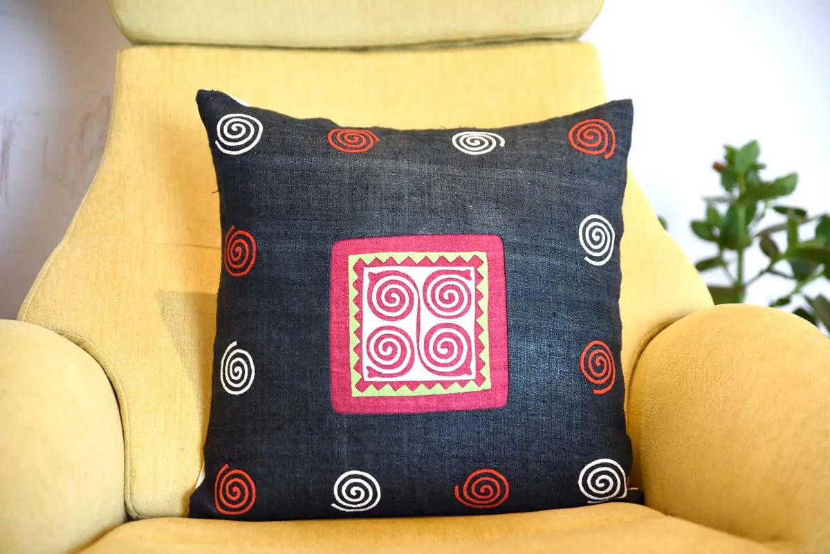 Vindigo black cushion cover with pink spiral on yellow chair