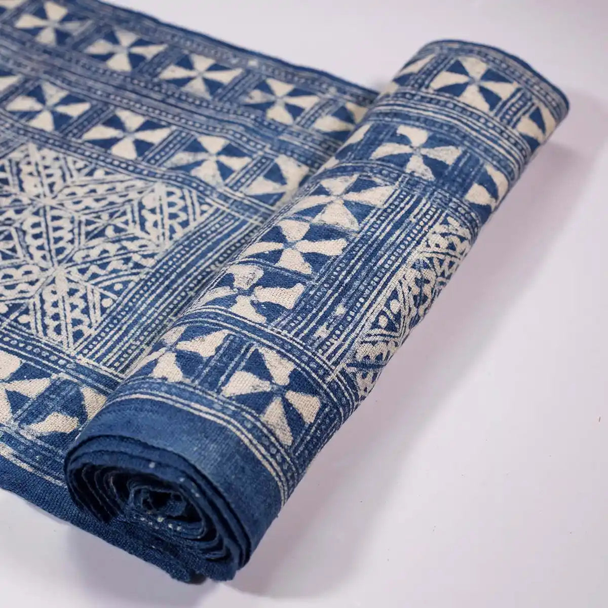 Vindigo indigo fabric roll with tribal triangle grid pattern, partially rolled