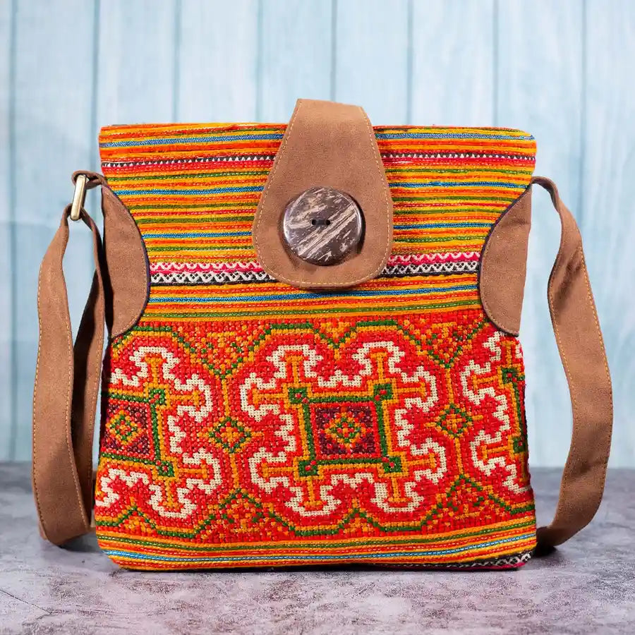 Vindigo orange hemp crossbody bag front view with traditional H’mong embroidery and coconut button