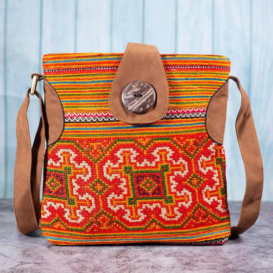 Vindigo orange hemp crossbody bag front view with traditional H’mong embroidery and coconut button
