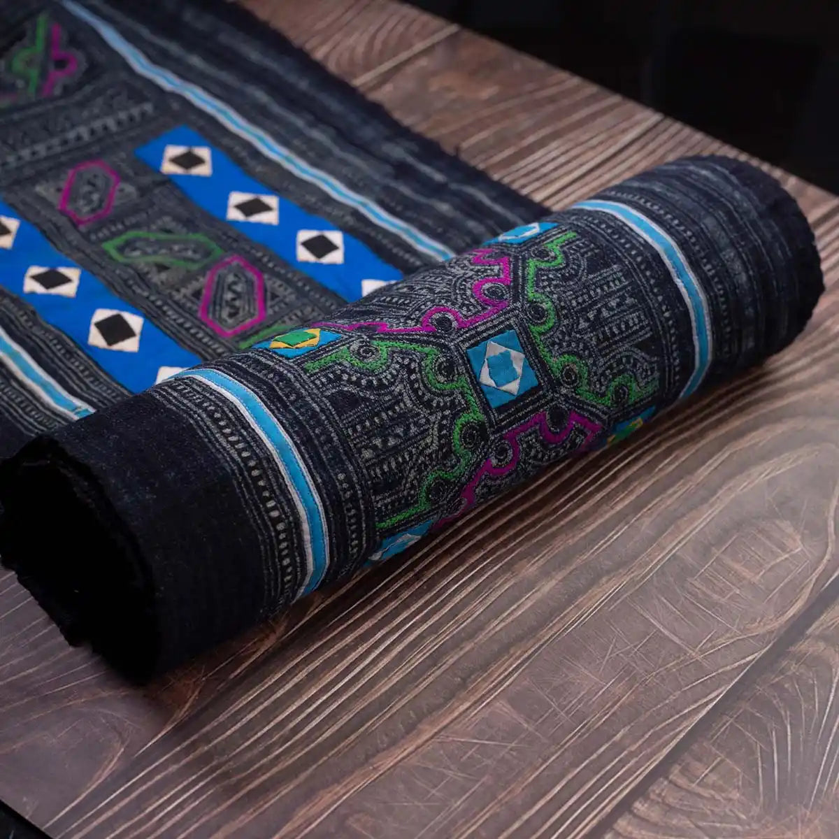 Vindigo black fabric roll with Hmong diamond panel embroidery, rolled view