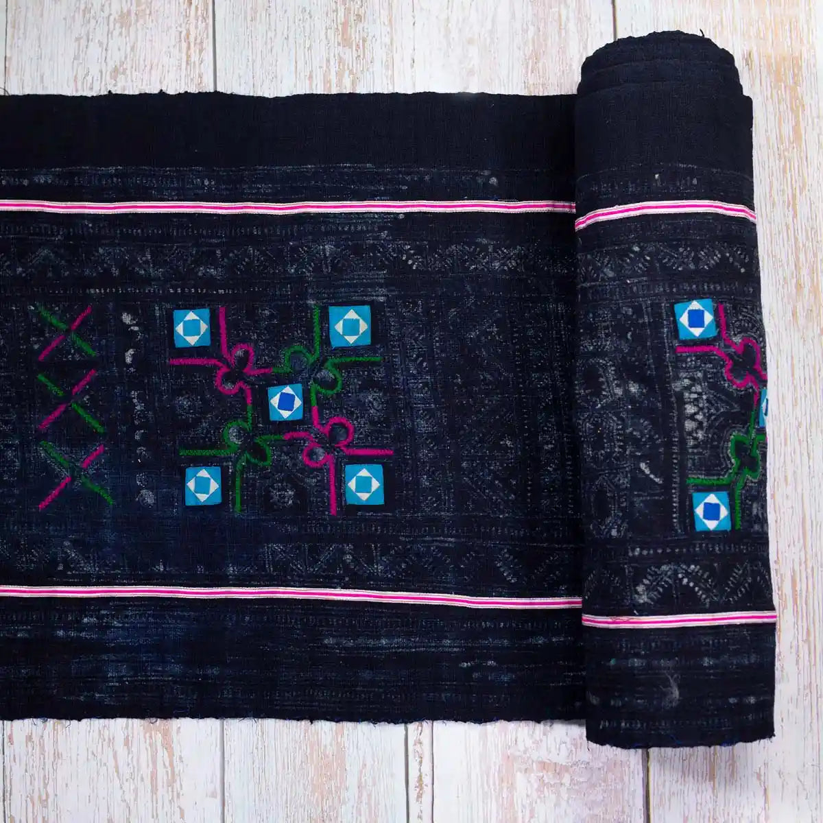 Vindigo black fabric roll with pastel pink border and Hmong square motifs