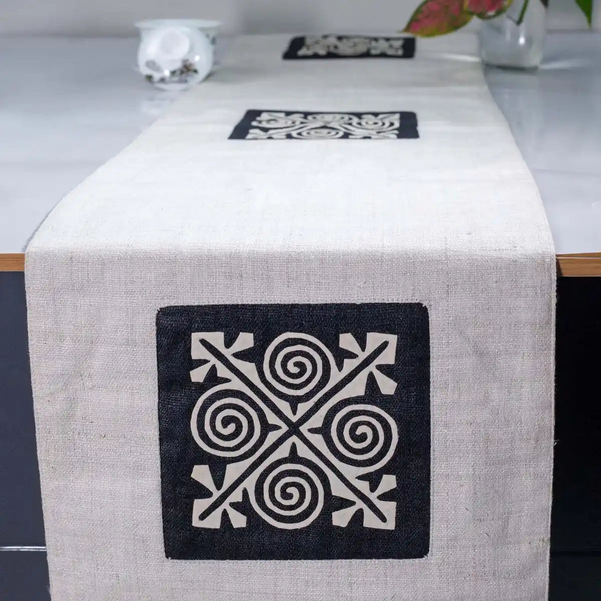 Vindigo beige hemp table runner front view featuring hand-embroidered geometric spiral motif