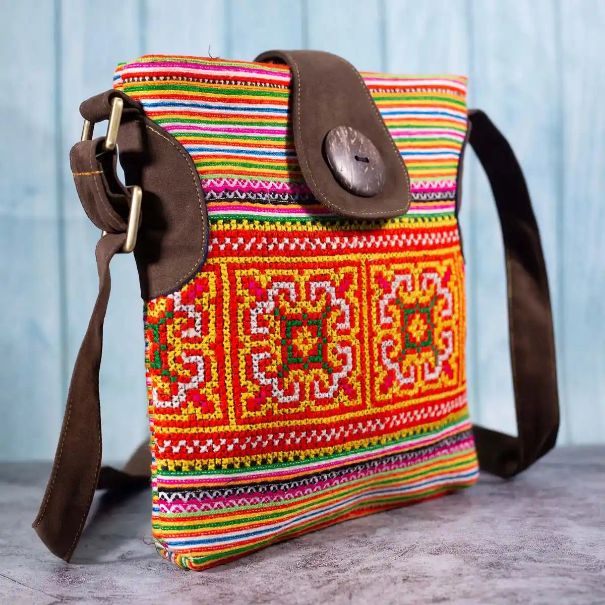 Vindigo orange hemp crossbody bag side view showing brown faux leather strap