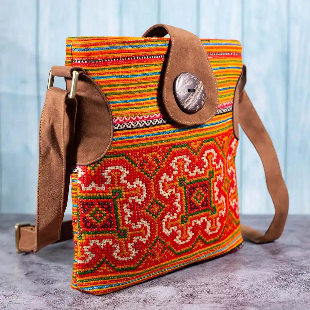 Vindigo orange hemp crossbody bag side angle showing faux leather strap and bright patterns