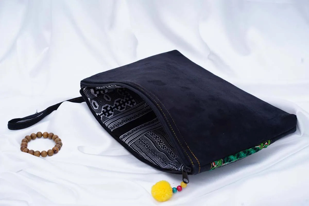 Folded view of handmade black hemp clutch with tribal inner lining