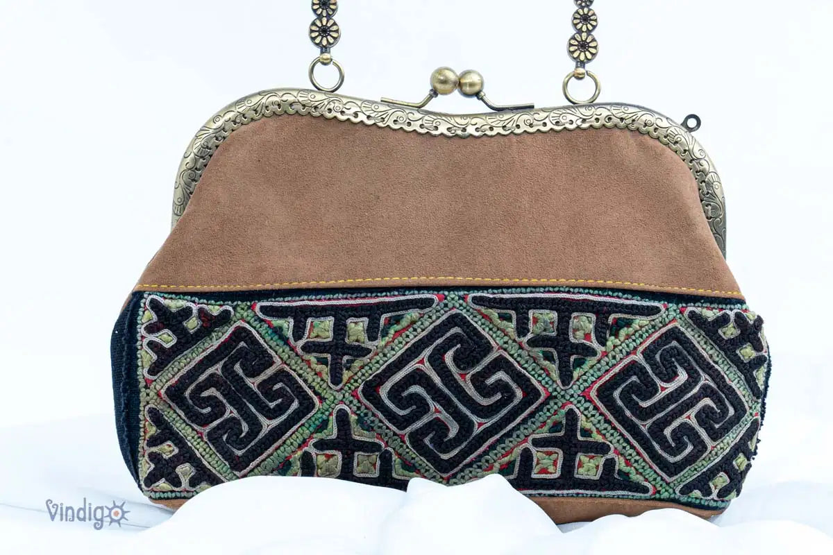 Close-up of brown suede handbag with geometric vintage embroidery