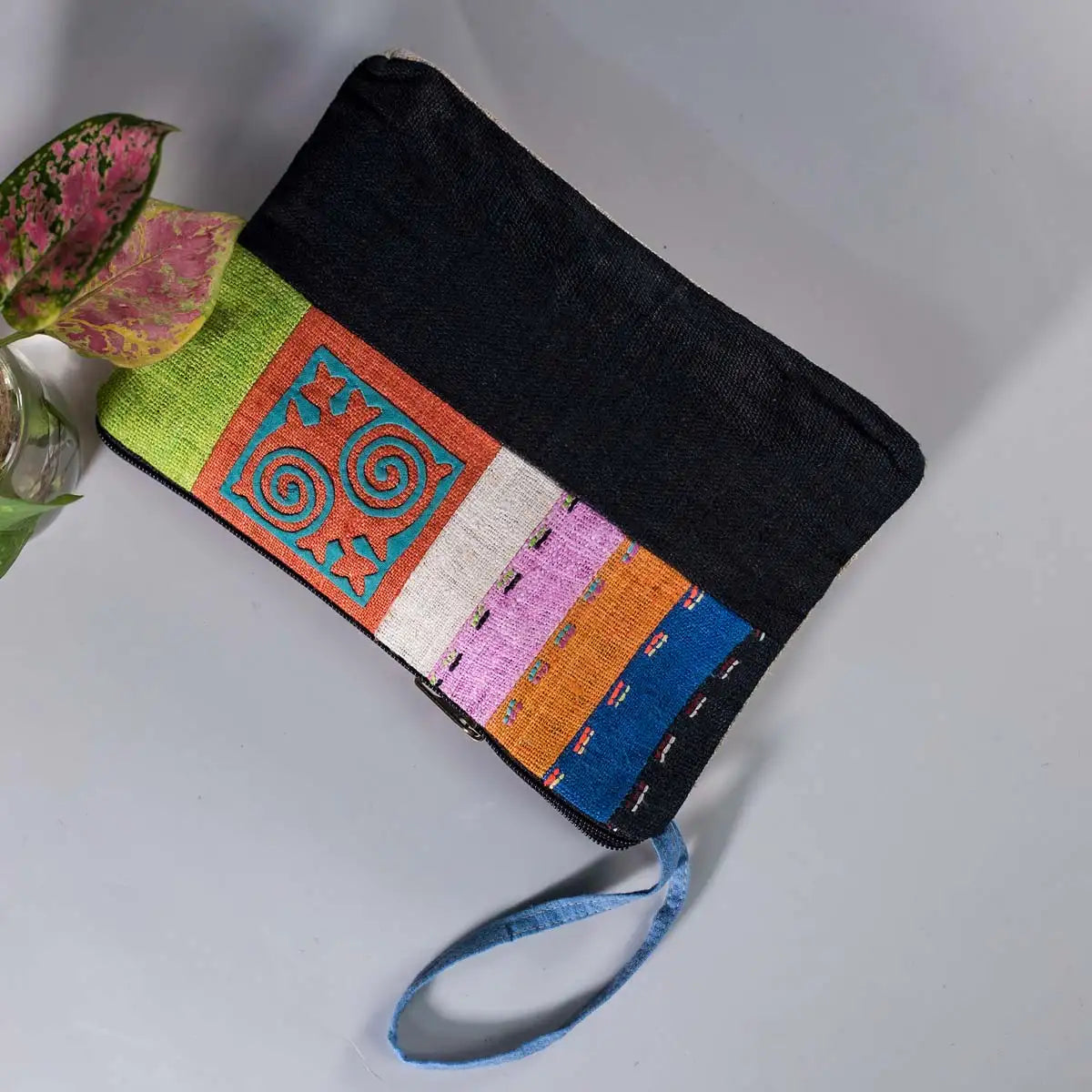Vindigo hemp cosmetic bag flat lay showing black base and bright H’mong embroidery
