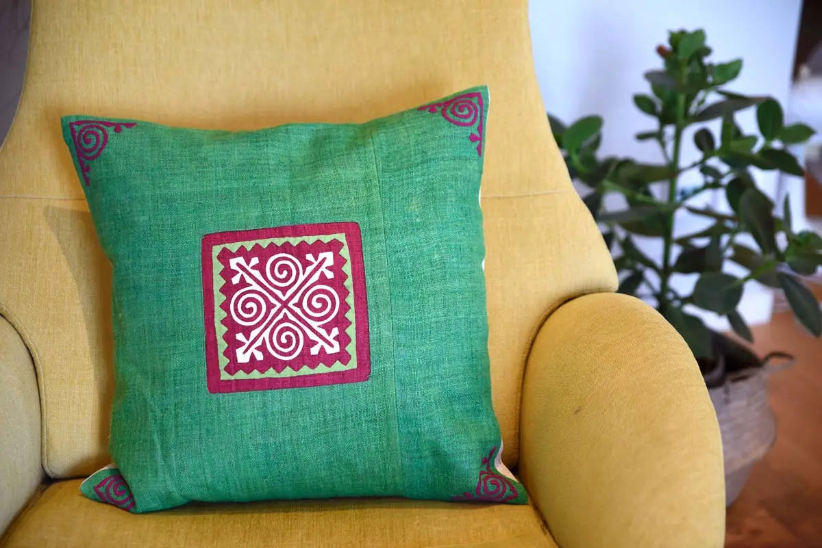 Green hemp cushion with red spiral design styled on yellow chair