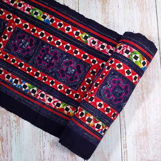 Vindigo black fabric roll with vivid hand embroidery, rolled side