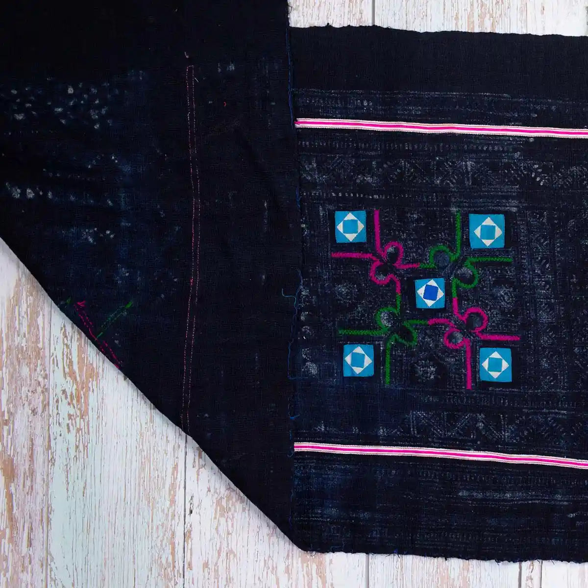 Vindigo tribal black fabric with turquoise squares and pink edges, flat layout