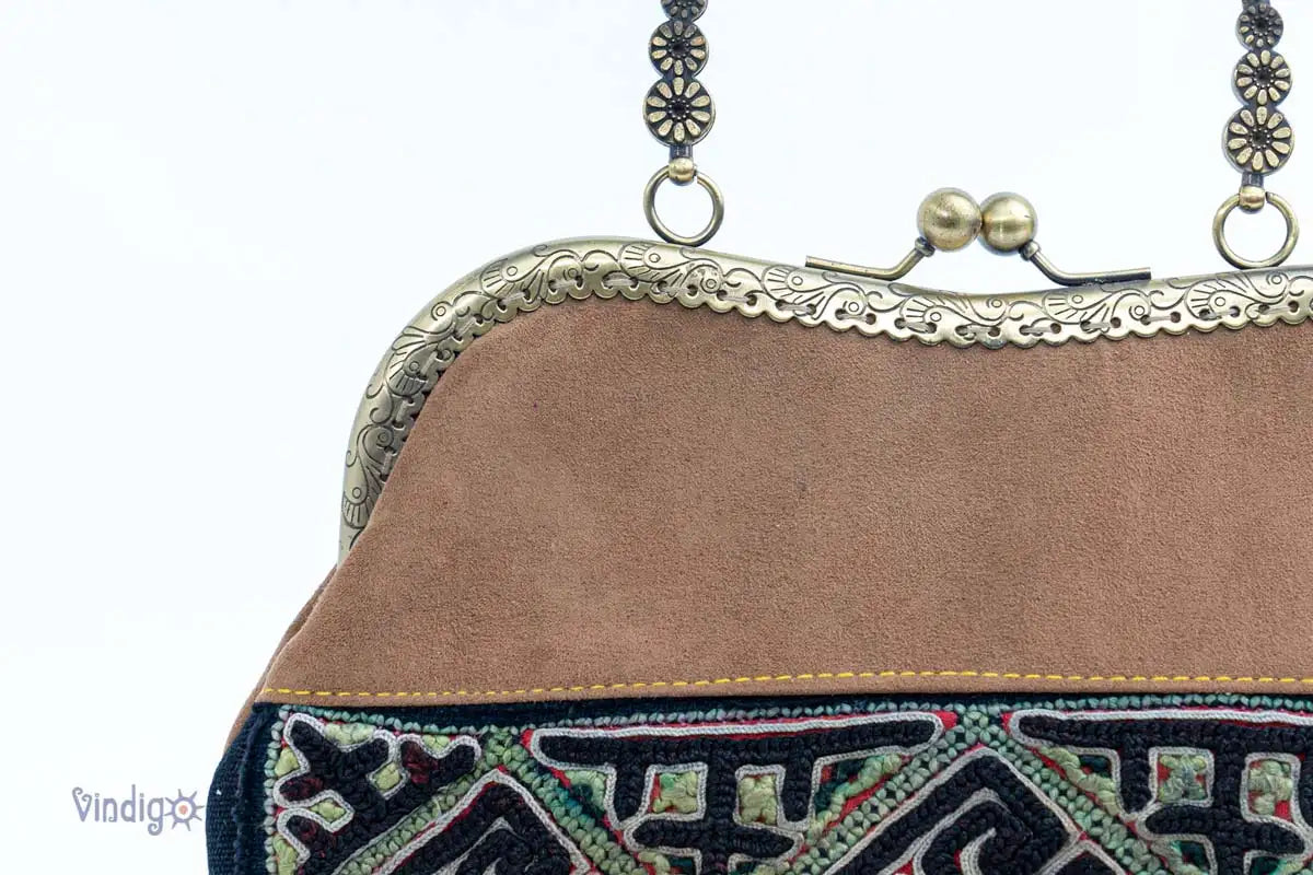 Detail view of copper handle and clasp on vintage embroidery handbag