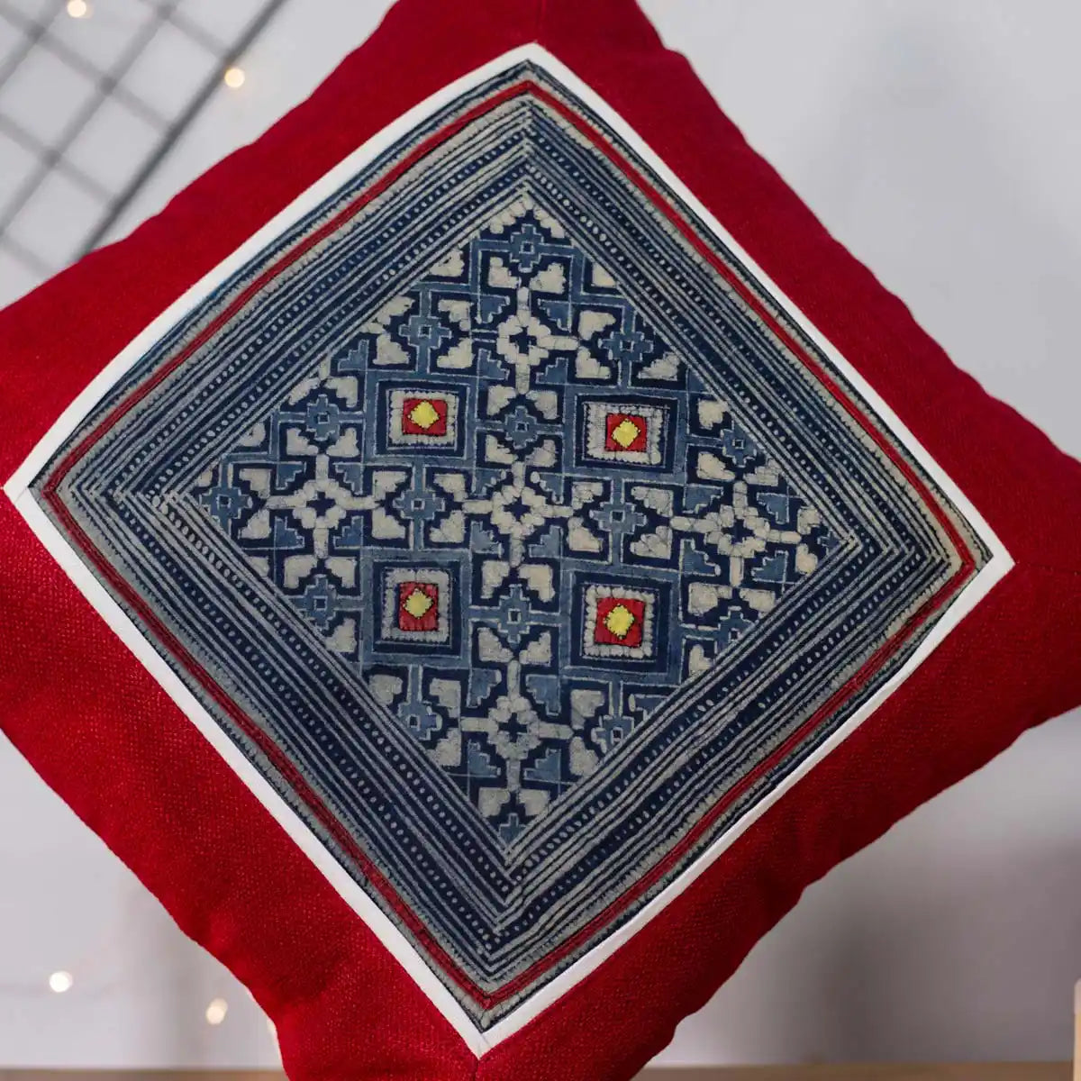 Vindigo red cushion cover close-up showing indigo batik and fine hand embroidery