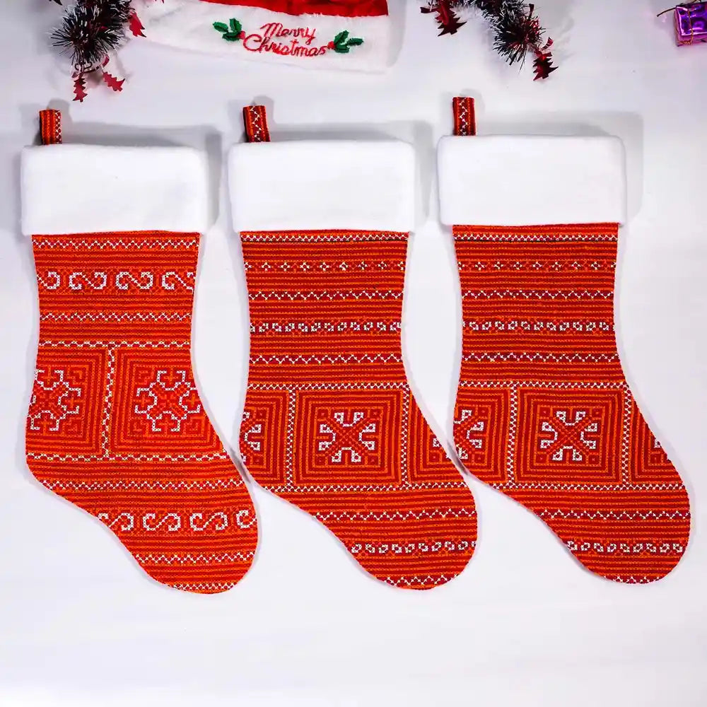 Three red Christmas stockings displayed with decorations