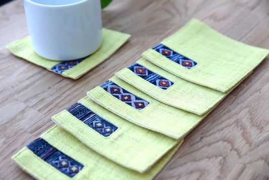 Set of handmade yellow hemp coasters with blue tribal detail