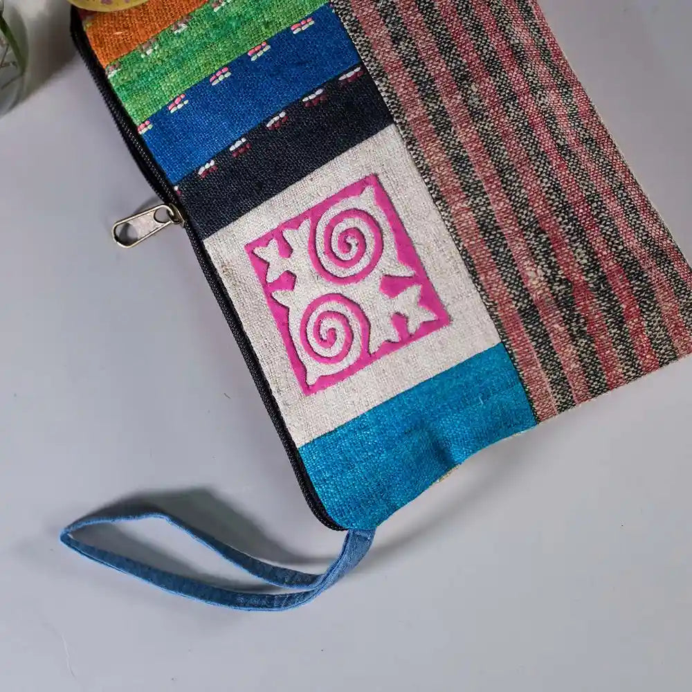 Vindigo hemp cosmetic bag side view highlighting hand-embroidered pink spiral