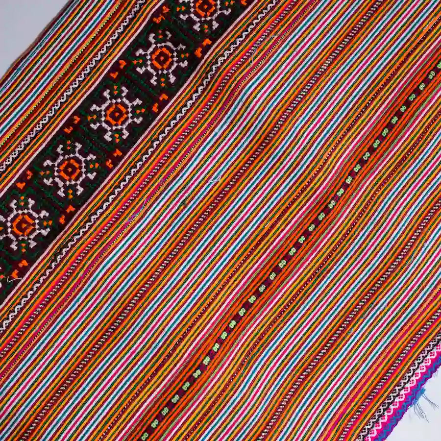 Vindigo orange cotton fabric roll with colorful stripes and black floral trim