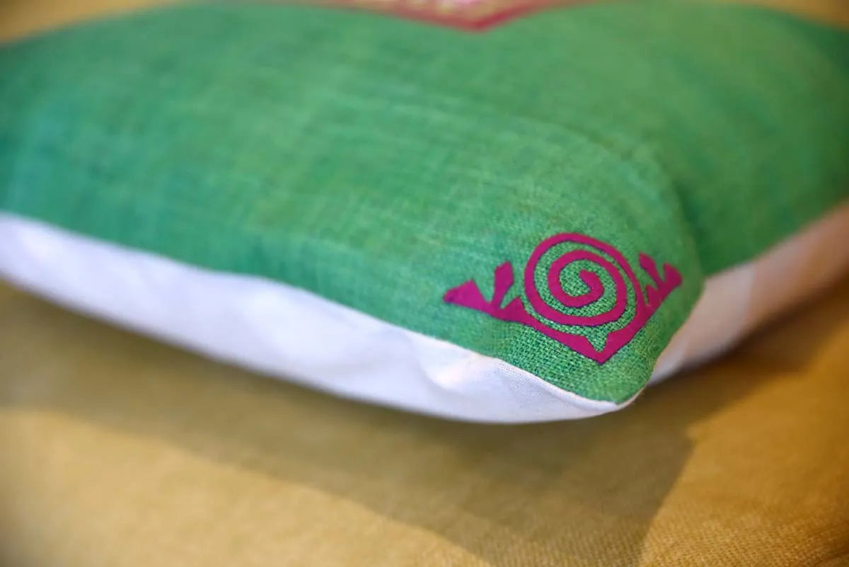 Red spiral corner detail on green hemp cushion, angled side view