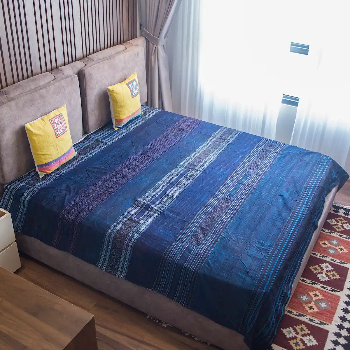 Vindigo indigo hand-embroidered Hmong cotton bed cover on king-size bed
