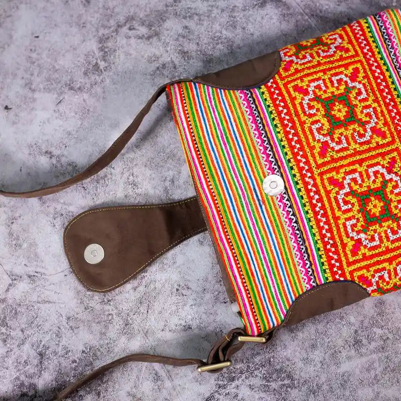 Vindigo orange embroidered crossbody bag flat lay showing magnetic strap button