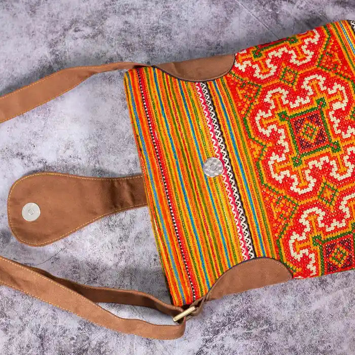 Vindigo orange hemp crossbody bag flat lay showing magnet button and detailed stitching