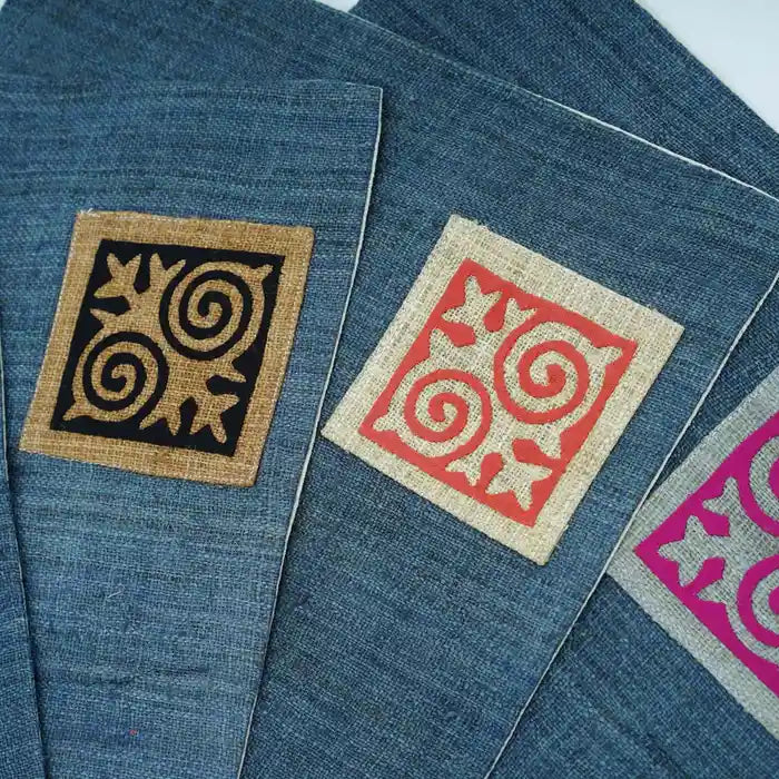 Geometriska tribaltryck i svart och orange på blå bomullsservett