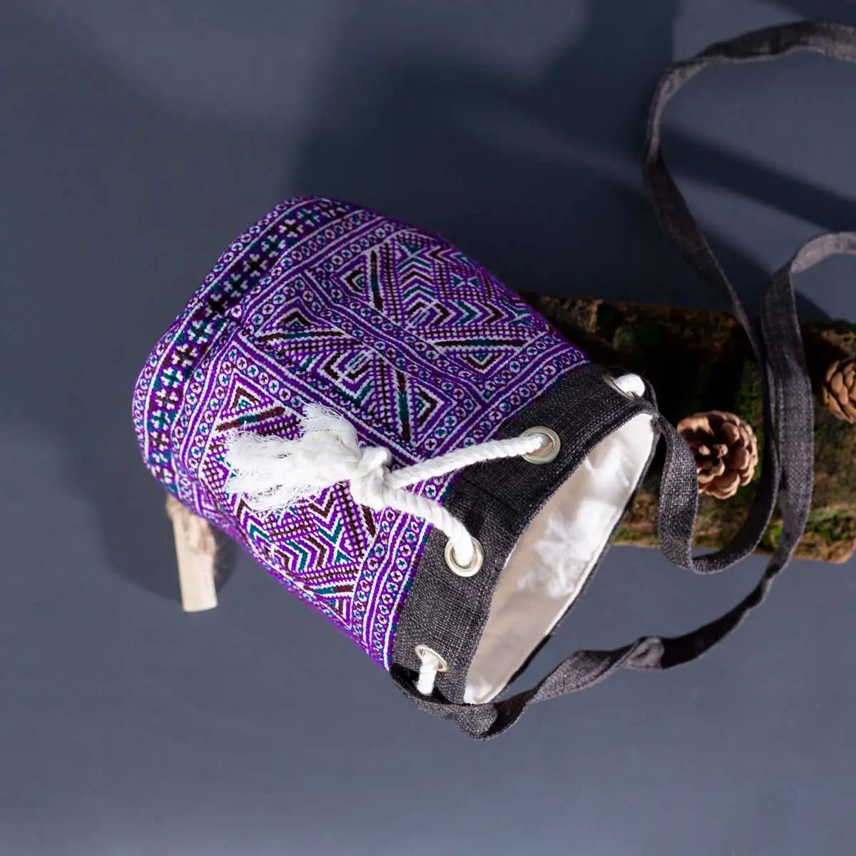 Side angle of Vindigo purple hemp floral bucket bag on wooden surface