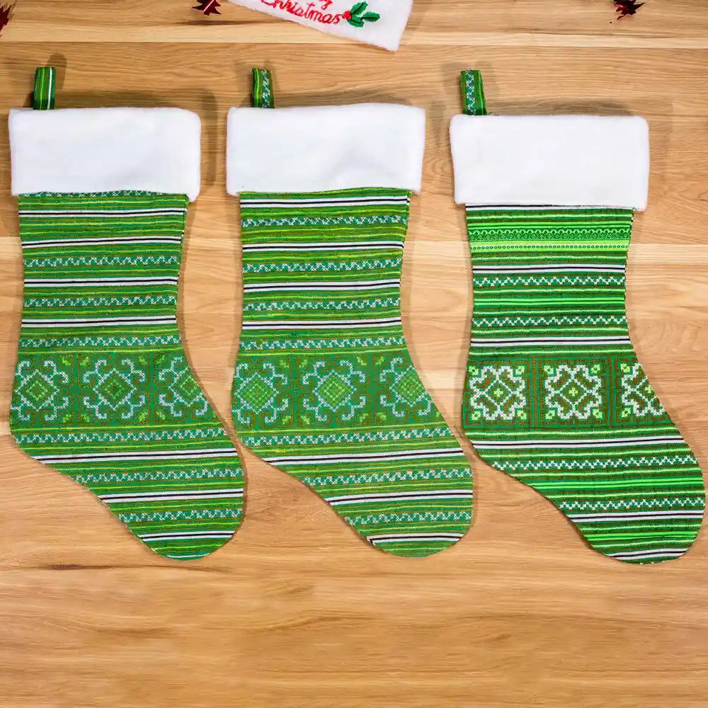 Vindigo set of green embroidered Christmas stockings front on wooden background