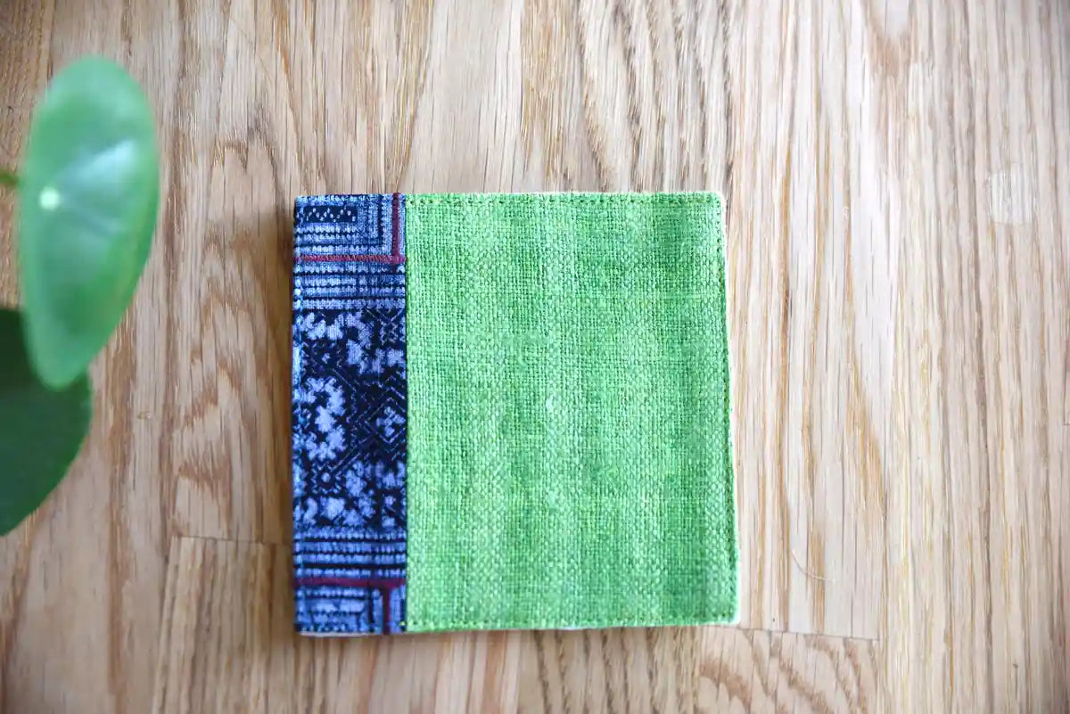 Front view of green hemp coaster with indigo woven edge