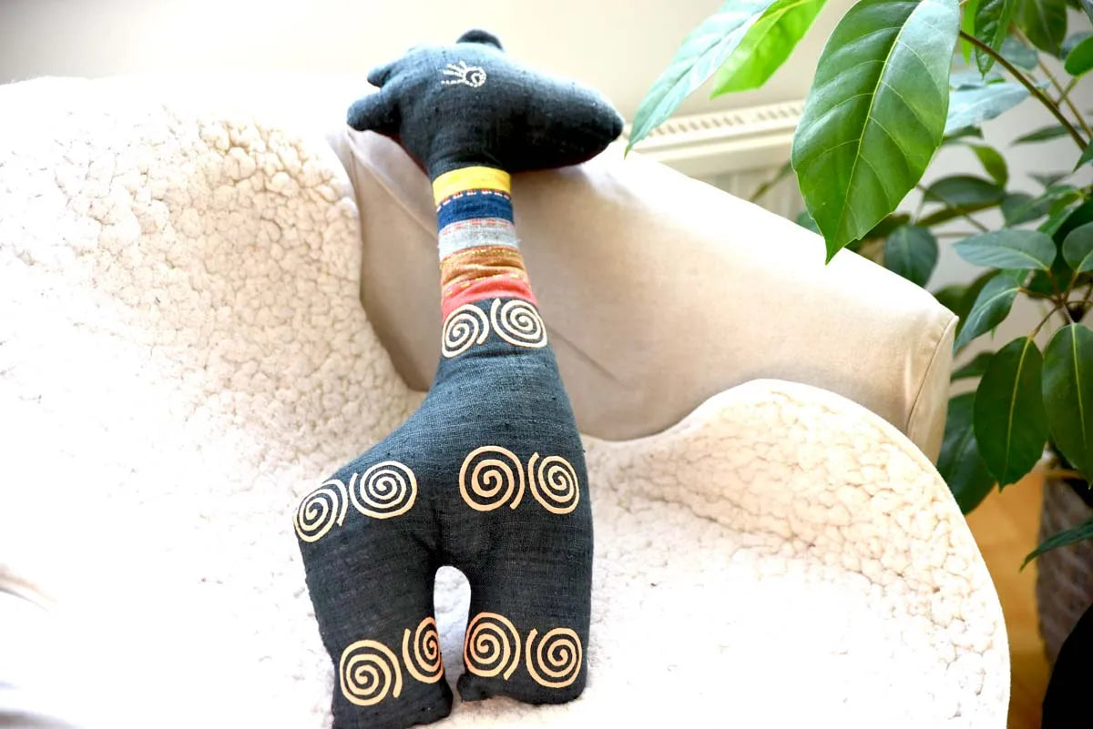 Spiral hemp deer plush toy upright next to plant in lounge chair