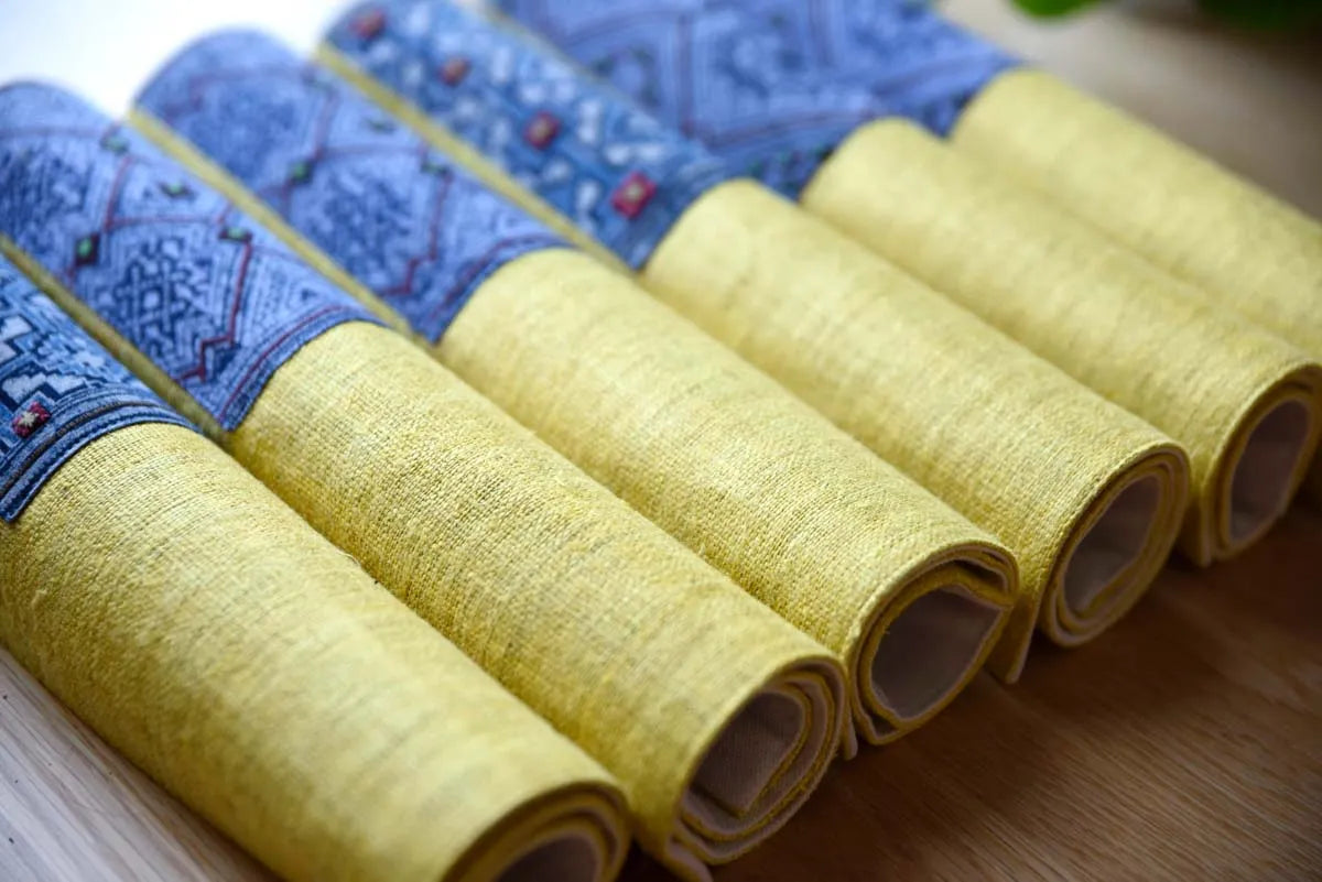 Rolled yellow and indigo hemp napkins with geometric patterns