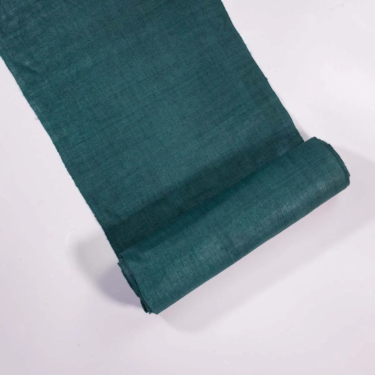 Vindigo green hemp fabric roll laid flat on white background