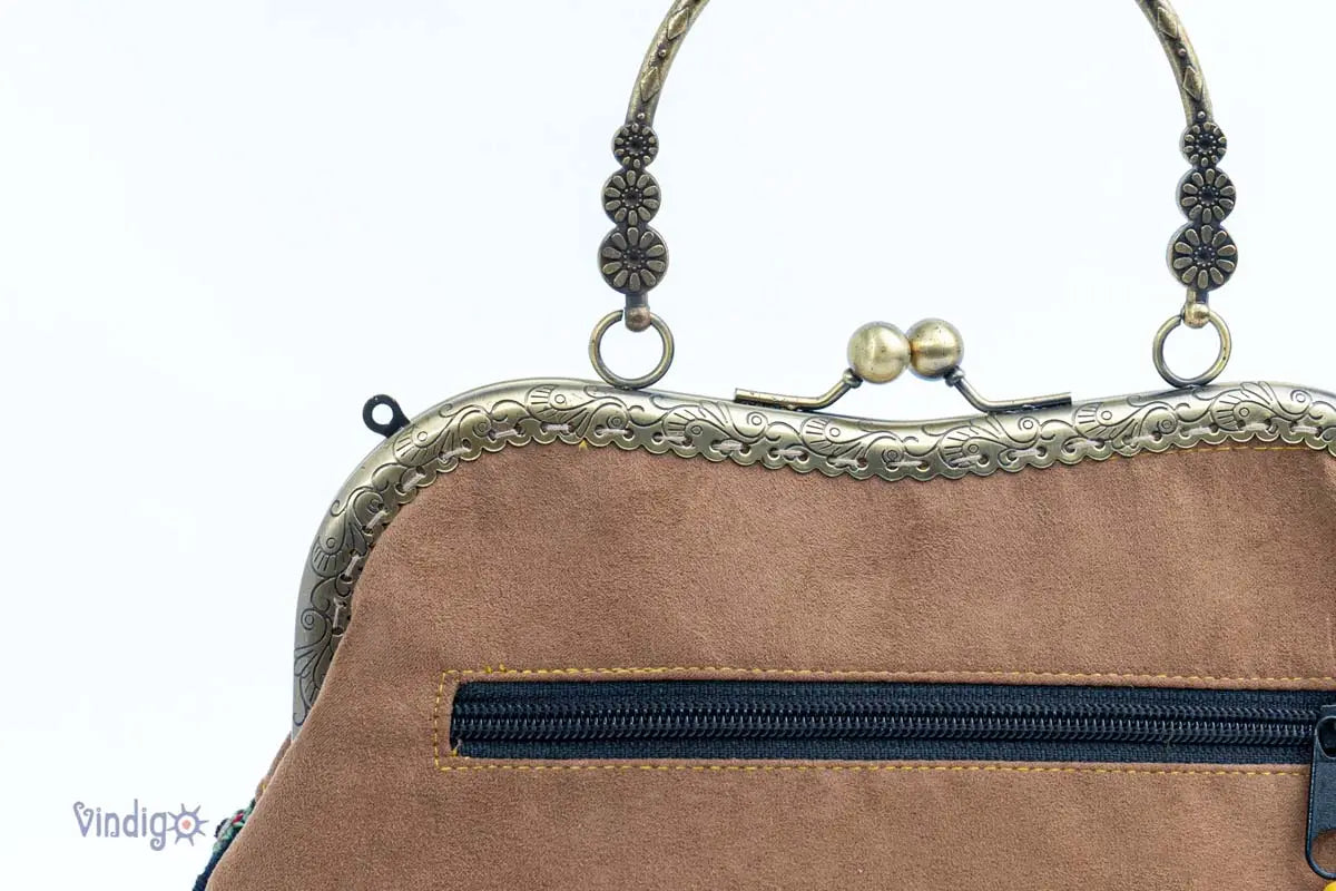 Detail of back zipper and copper binding on handbag